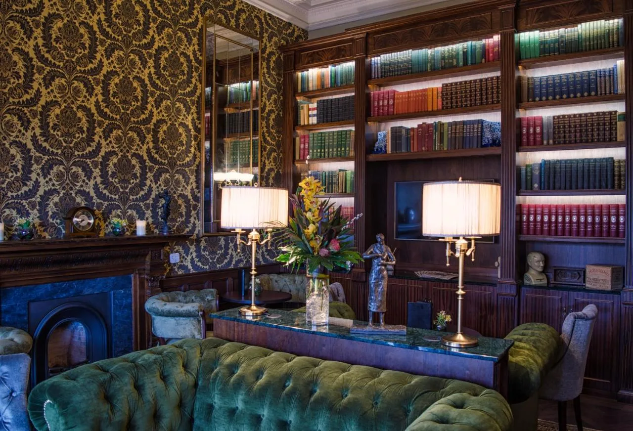 a living room with a couch and bookshelves at The Bonham in Edinburgh