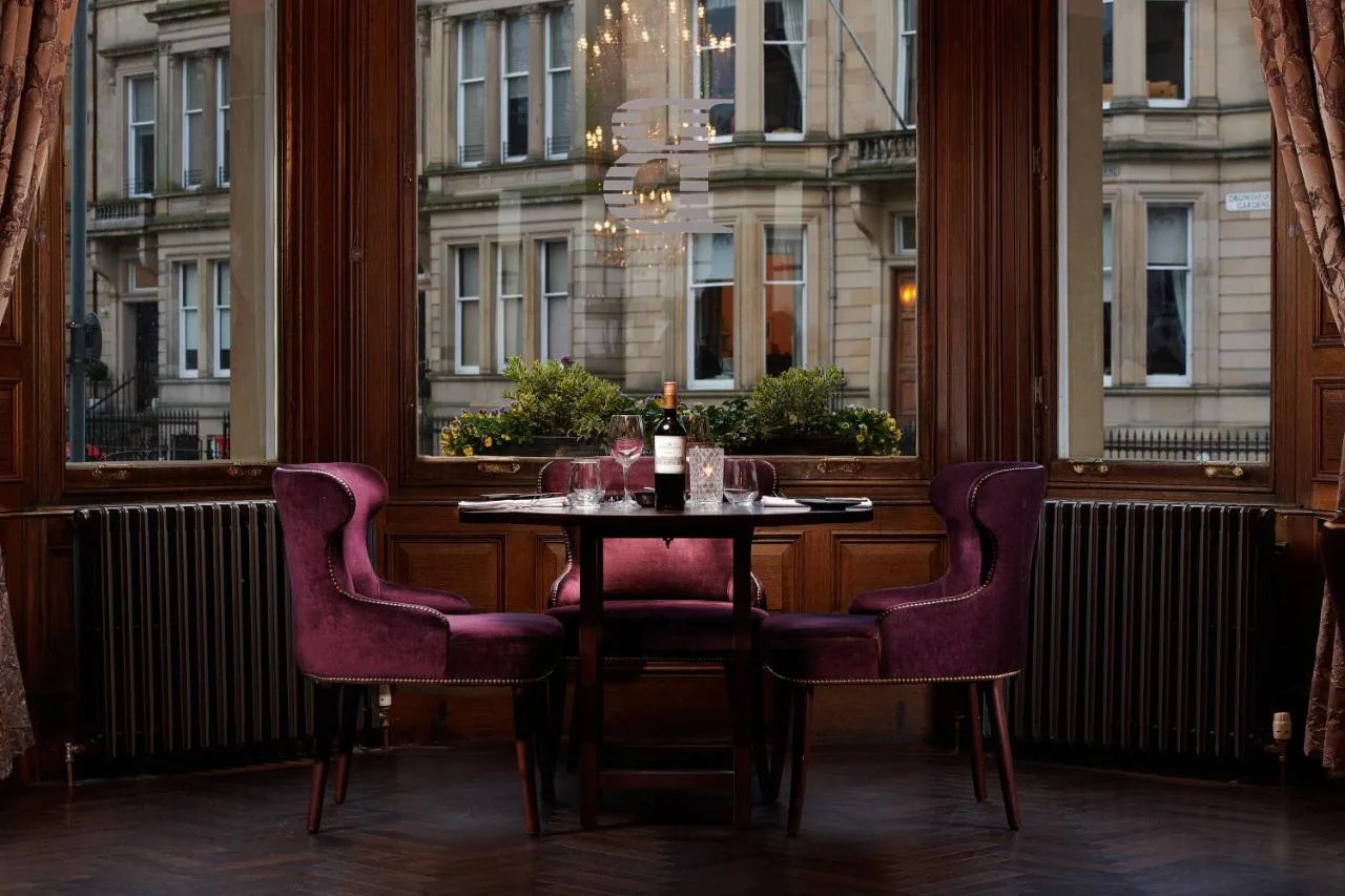 a table and chairs in a room with a window at The Bonham in Edinburgh